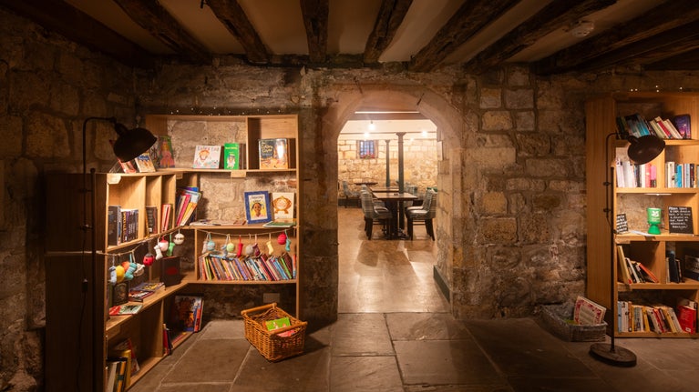wooden bookshelves filled with books in a stone room